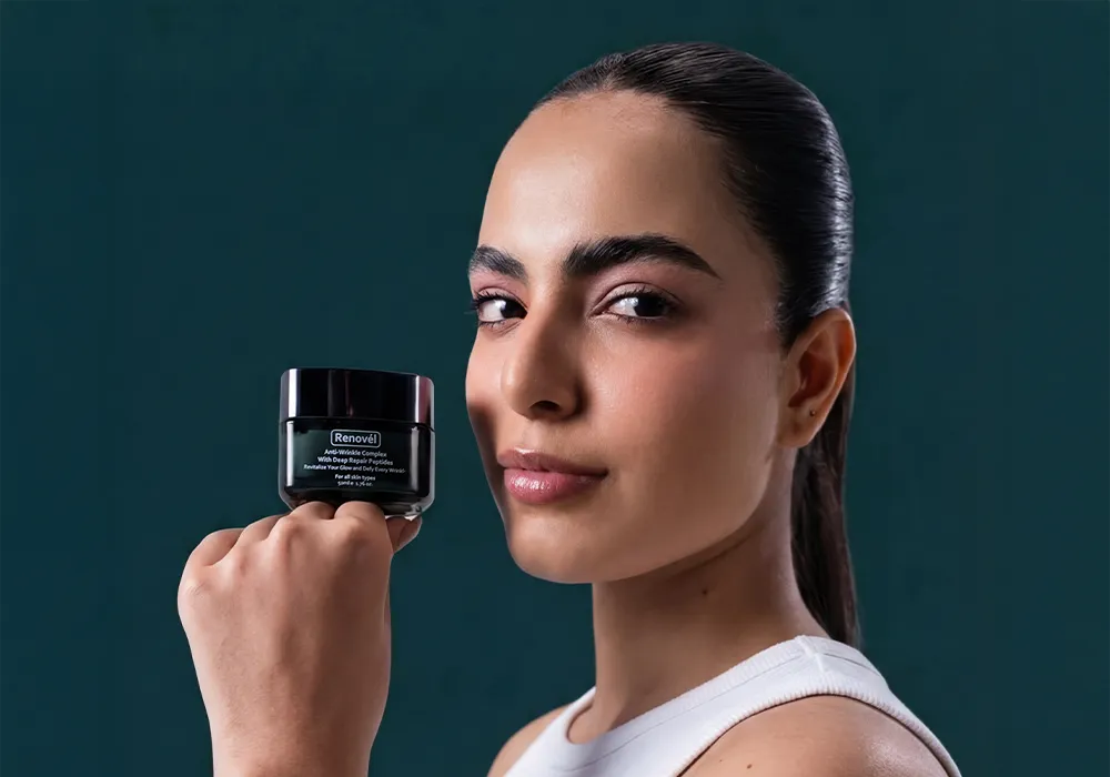 Woman holding a peptide night cream designed to support overnight skin repair, improve firmness, and restore a smoother complexion.
